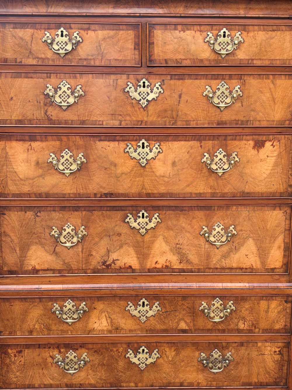 An eighteenth-century George II walnut chest on chest featuring two short over six long graduated drawers with decorative brass handles, keyhole escutcheons, and bracket feet. View III