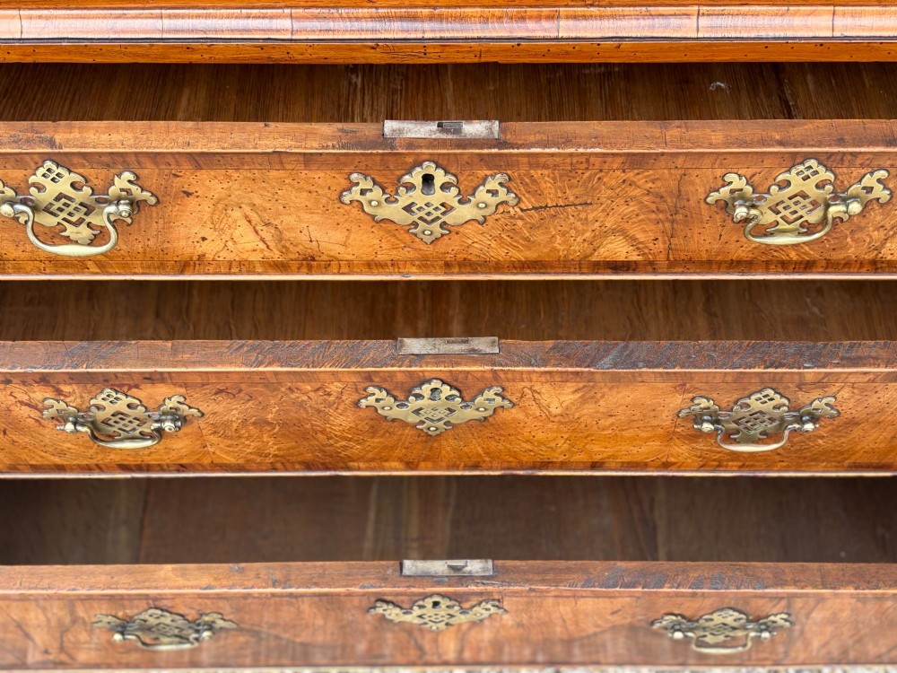 An eighteenth-century George II walnut chest on chest featuring two short over six long graduated drawers with decorative brass handles, keyhole escutcheons, and bracket feet. View V