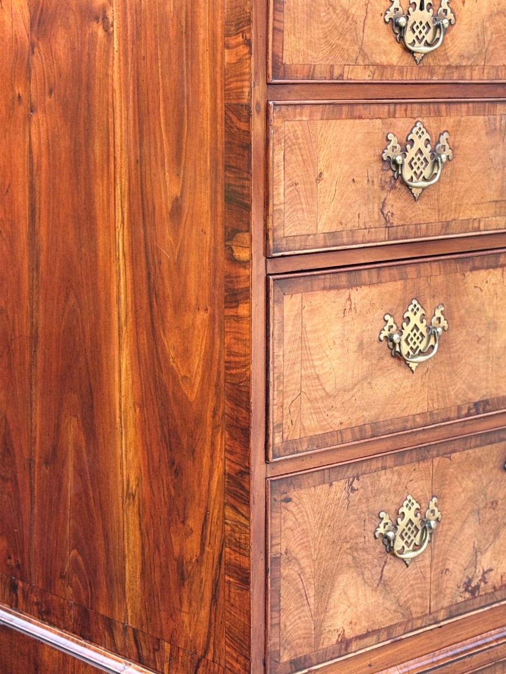 An eighteenth-century George II walnut chest on chest featuring two short over six long graduated drawers with decorative brass handles, keyhole escutcheons, and bracket feet. View X