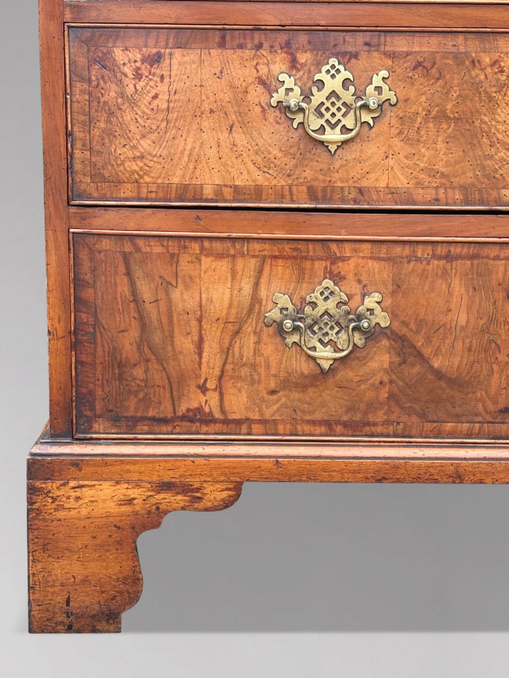 An eighteenth-century George II walnut chest on chest featuring two short over six long graduated drawers with decorative brass handles, keyhole escutcheons, and bracket feet. View XII