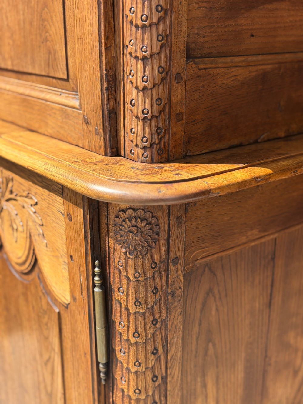 An 18th-century carved oak French buffet deux corps featuring upper glazed doors lined with fabric above a panelled lower cabinet with relief carvings. View XI