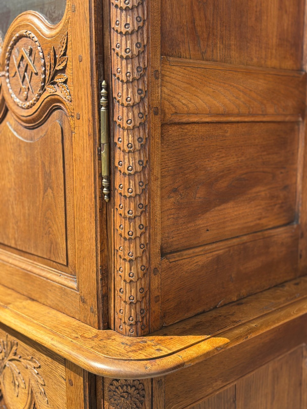 An 18th-century carved oak French buffet deux corps featuring upper glazed doors lined with fabric above a panelled lower cabinet with relief carvings. View XIV