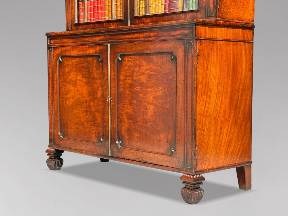 An eighteenth-century George III tall mahogany bookcase featuring two upper astragal glazed doors, lower flame-veneered cabinet doors, and a moulded cornice. View III