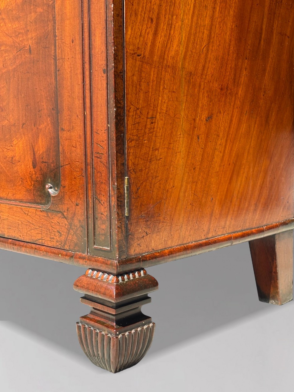 An eighteenth-century George III tall mahogany bookcase featuring two upper astragal glazed doors, lower flame-veneered cabinet doors, and a moulded cornice. View IX