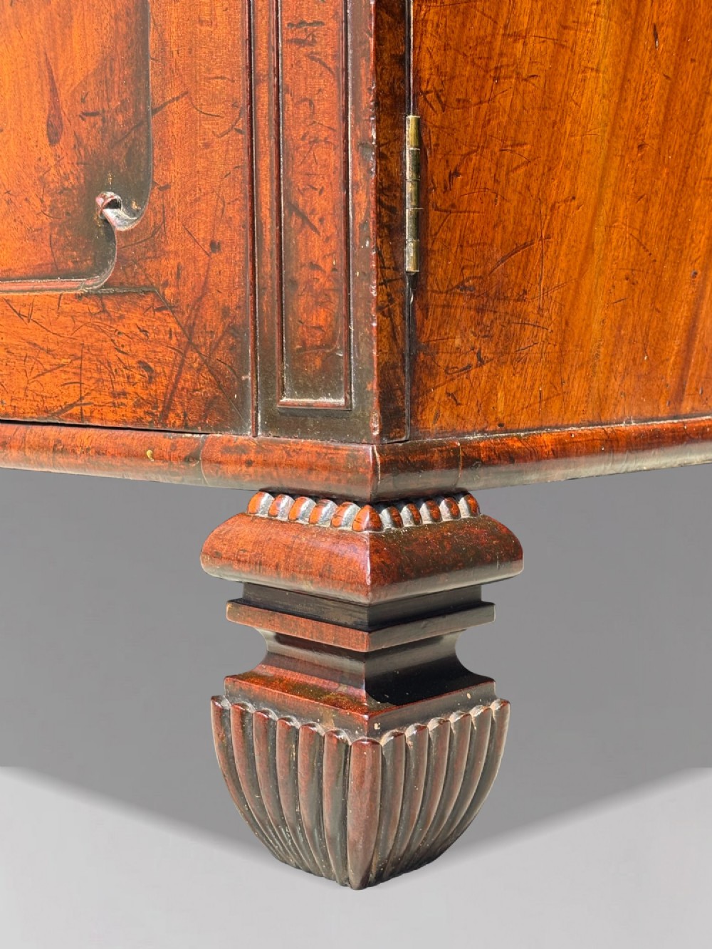 An eighteenth-century George III tall mahogany bookcase featuring two upper astragal glazed doors, lower flame-veneered cabinet doors, and a moulded cornice. View XII