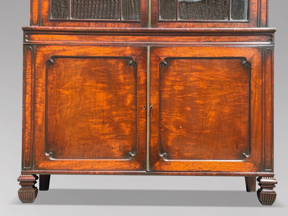 An eighteenth-century George III tall mahogany bookcase featuring two upper astragal glazed doors, lower flame-veneered cabinet doors, and a moulded cornice. View XIII