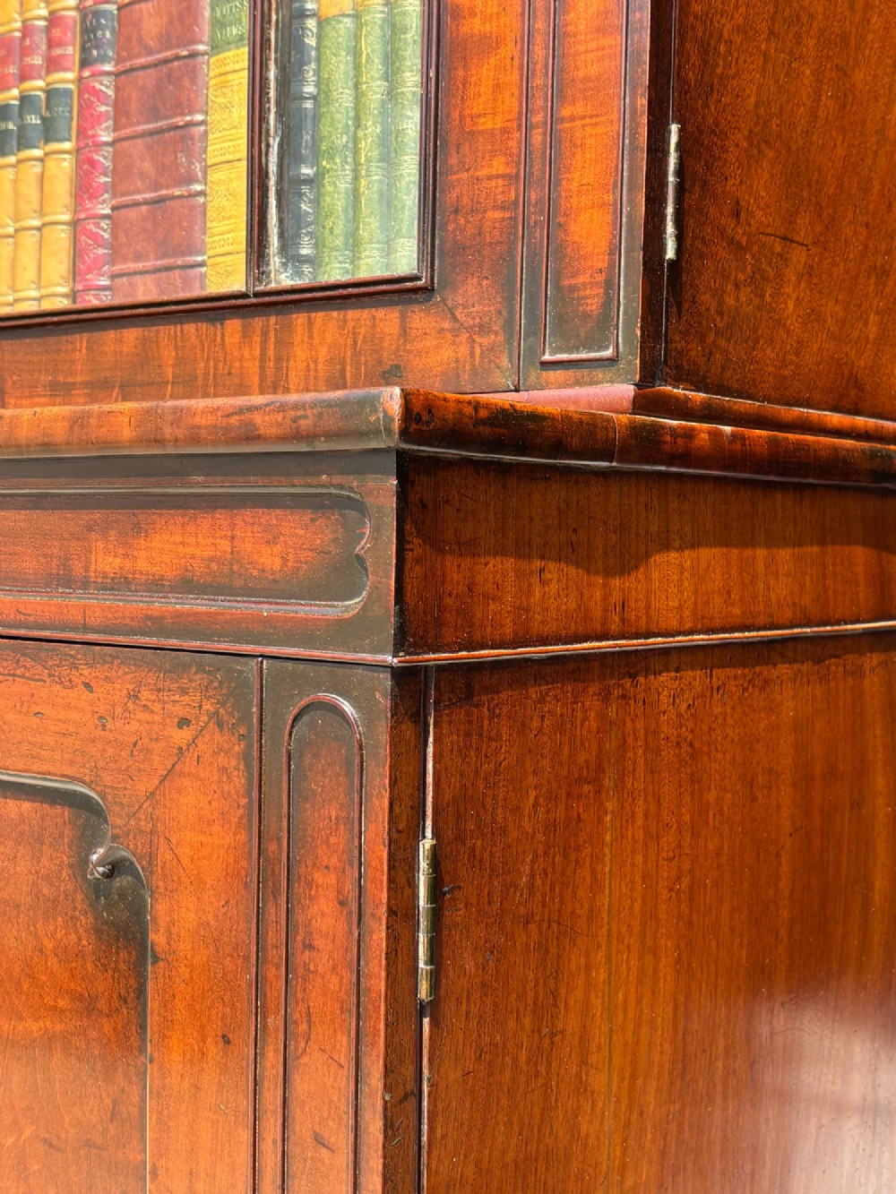 An eighteenth-century George III tall mahogany bookcase featuring two upper astragal glazed doors, lower flame-veneered cabinet doors, and a moulded cornice. View XIV