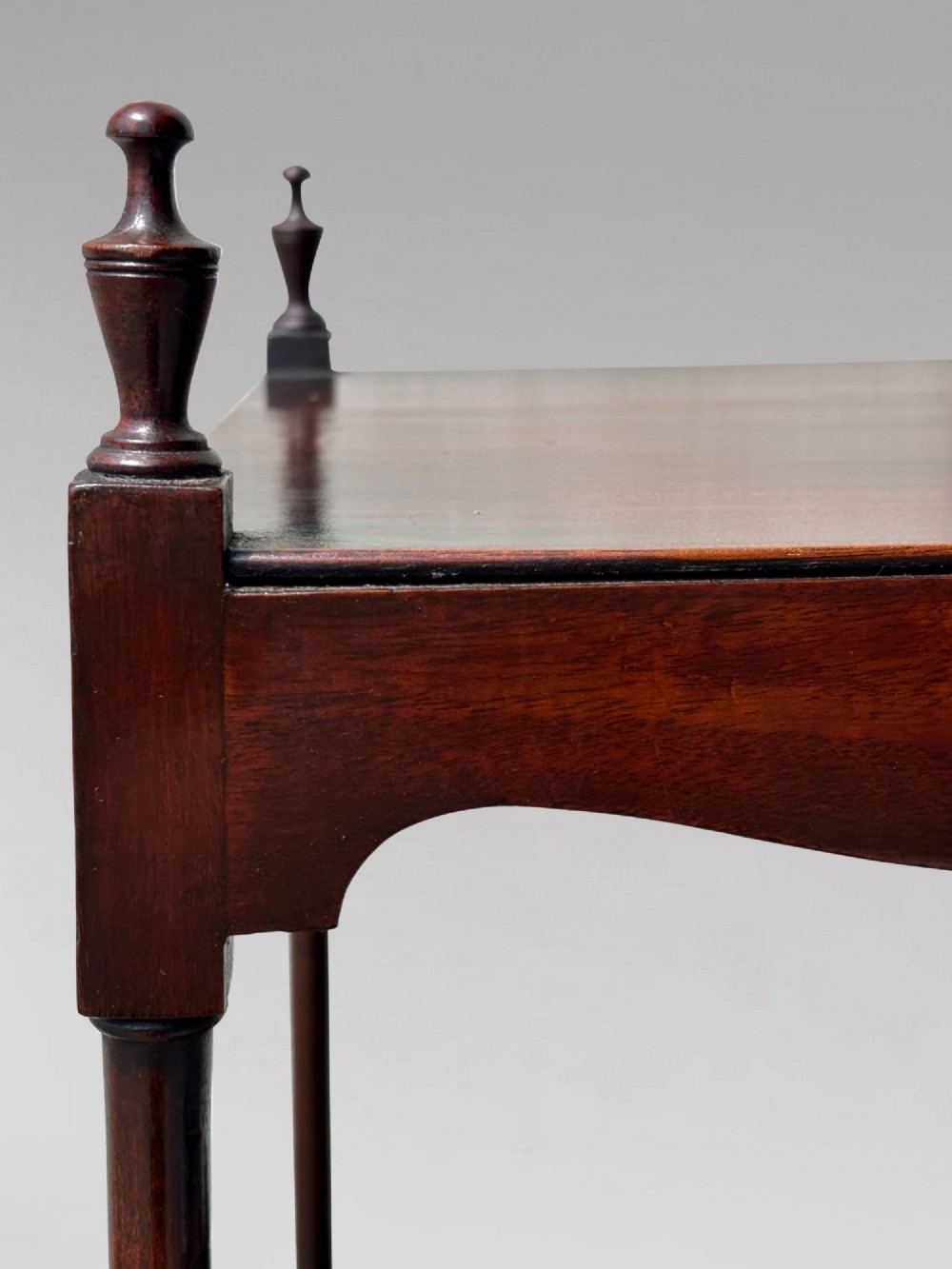 A four-tiered George III mahogany whatnot featuring slender corner supports, turned finials, scalloped aprons, and square tapered legs. View VIII