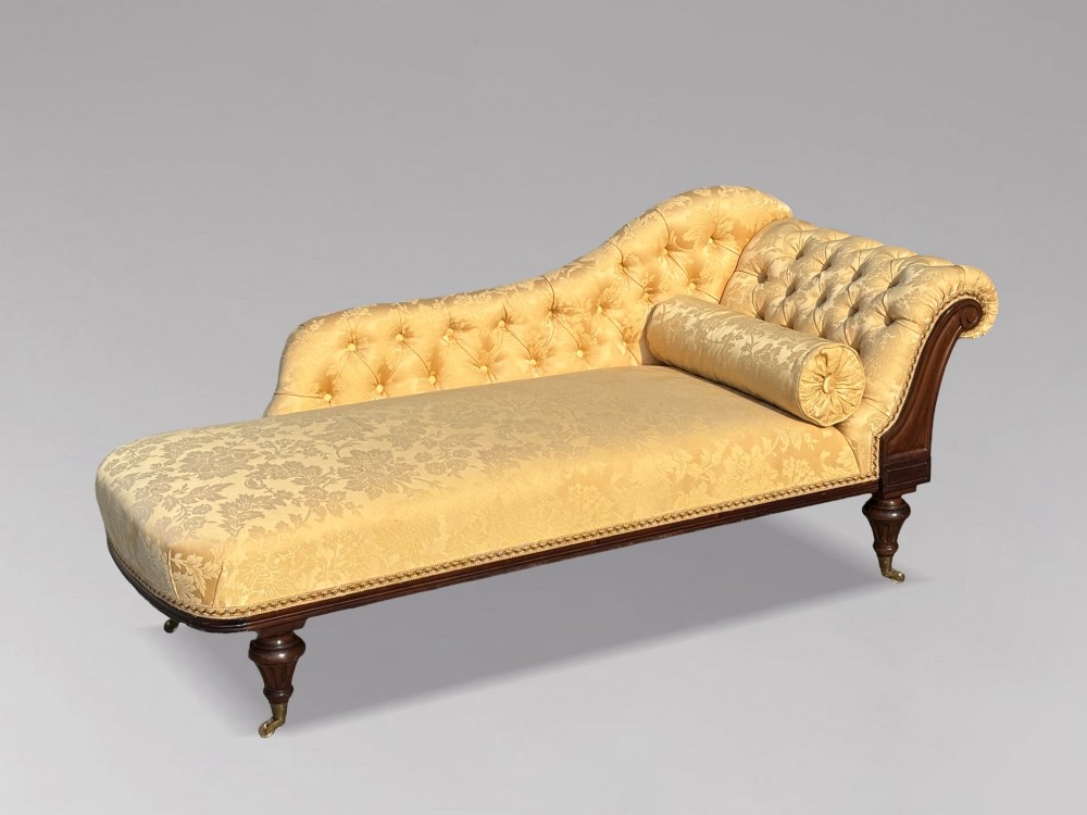 A 19th-century Regency mahogany chaise longue upholstered in yellow damask fabric with deep buttoning, a bolster cushion, and turned legs on brass castors. View III