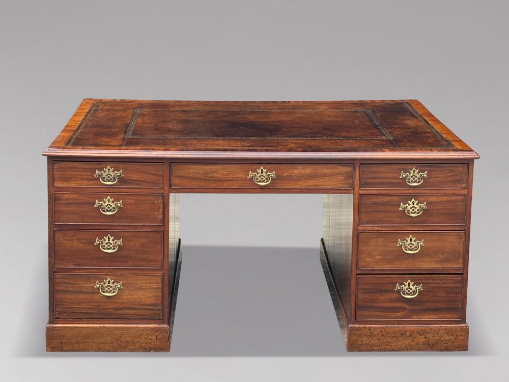 An 18th-century George III mahogany partners desk featuring an inset leather writing surface, brass swan-neck handles, and twin pedestals with stacked drawers. View II