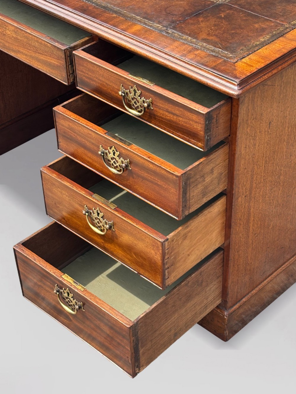 An 18th-century George III mahogany partners desk featuring an inset leather writing surface, brass swan-neck handles, and twin pedestals with stacked drawers. View IV