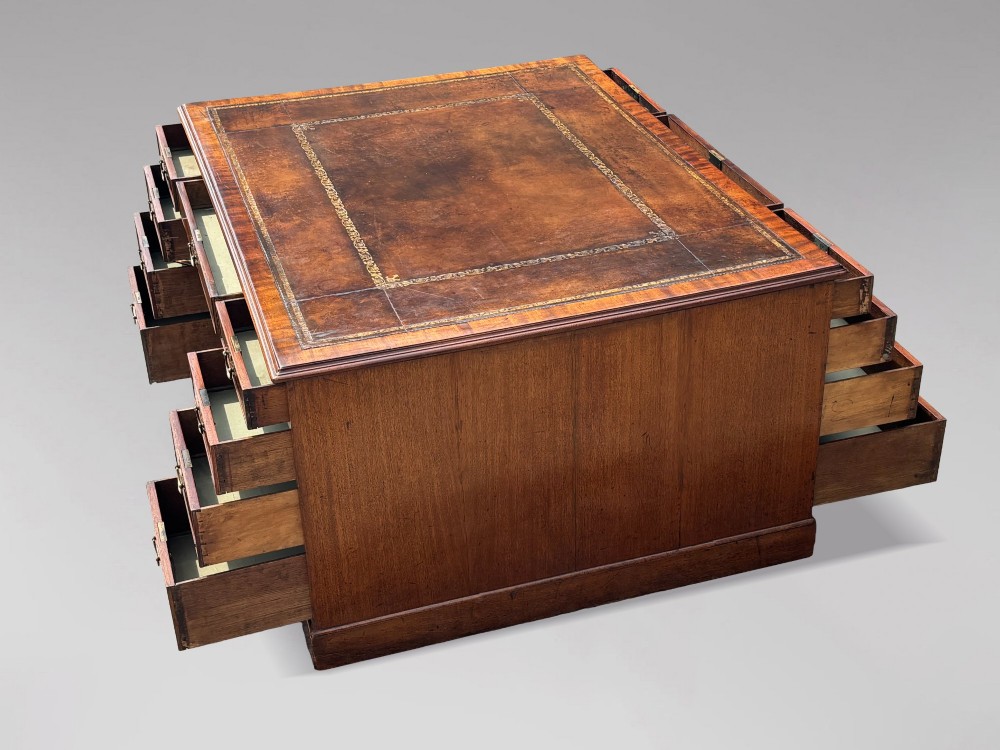 An 18th-century George III mahogany partners desk featuring an inset leather writing surface, brass swan-neck handles, and twin pedestals with stacked drawers. View VII