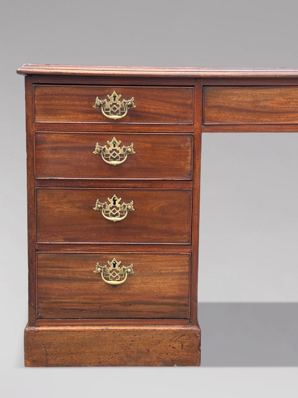 An 18th-century George III mahogany partners desk featuring an inset leather writing surface, brass swan-neck handles, and twin pedestals with stacked drawers. View XII
