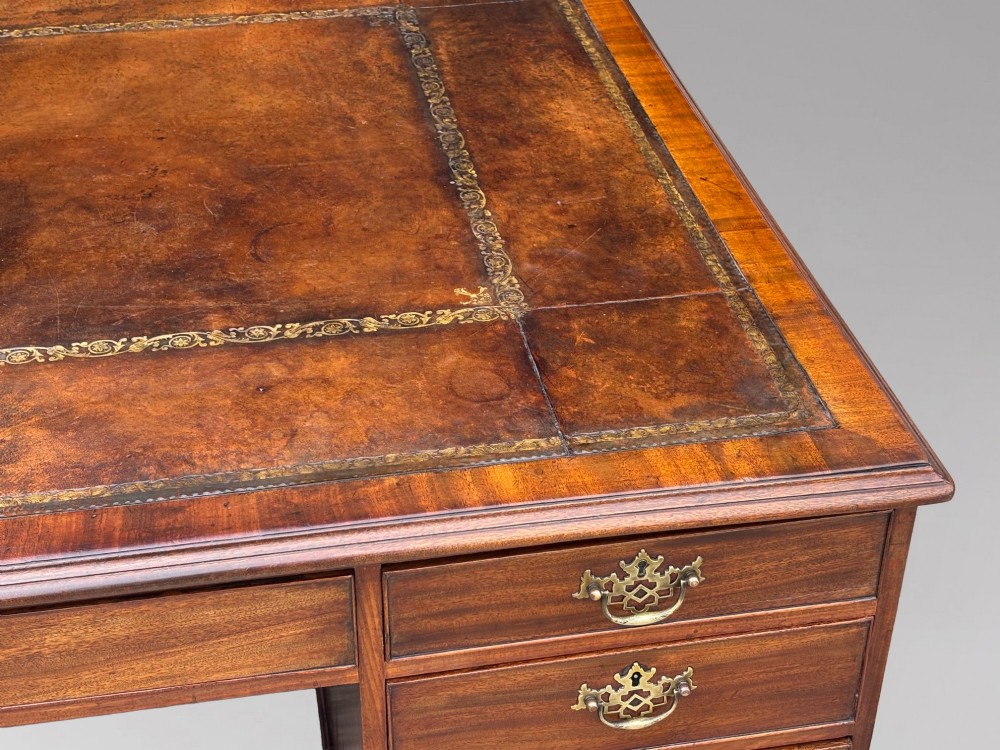 An 18th-century George III mahogany partners desk featuring an inset leather writing surface, brass swan-neck handles, and twin pedestals with stacked drawers. View XIII