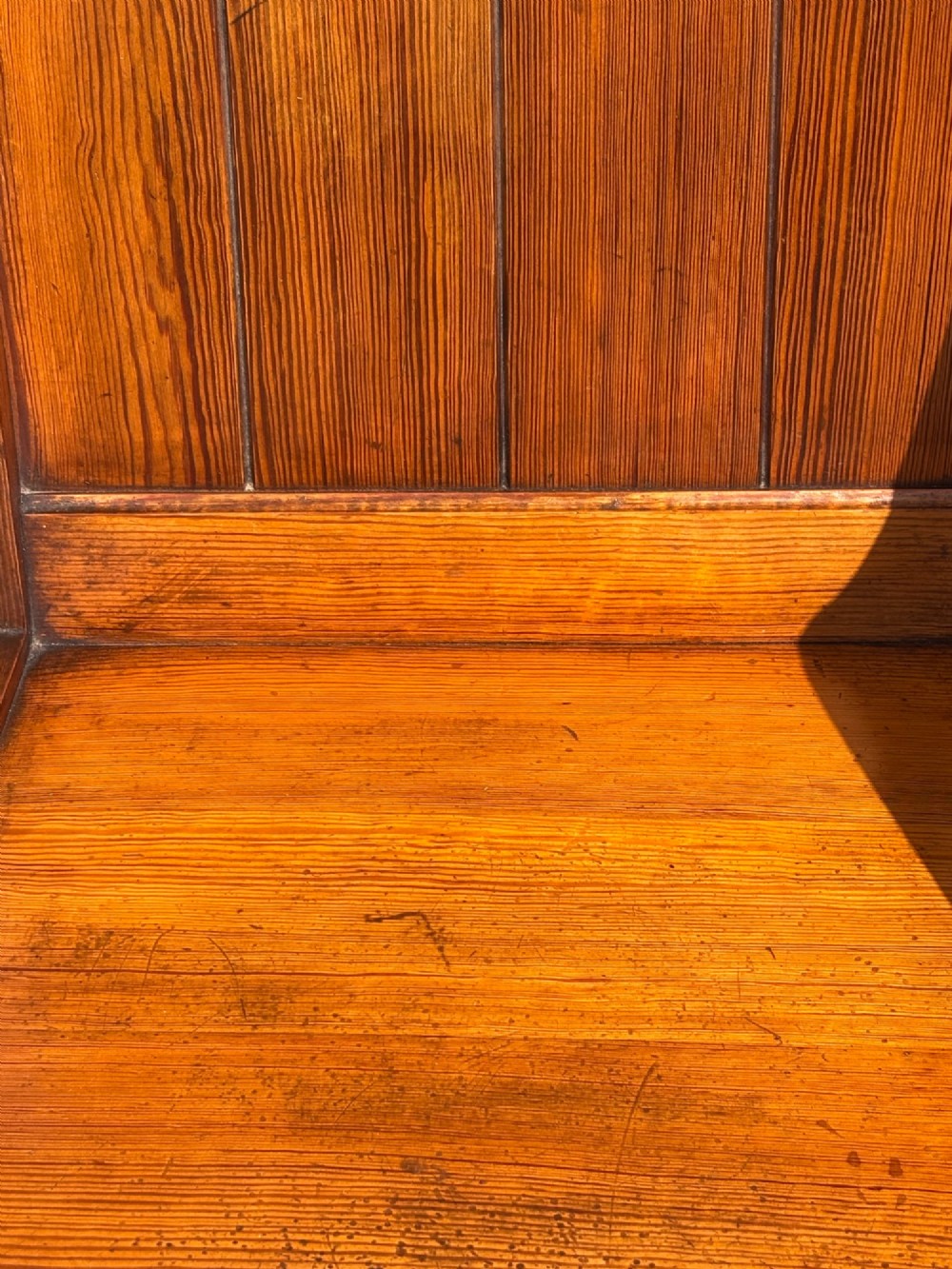 A pair of Victorian pitch pine Glastonbury armchairs featuring sloped armrests, X-frame bases, and pierced trefoil motifs on the back panels. View VI