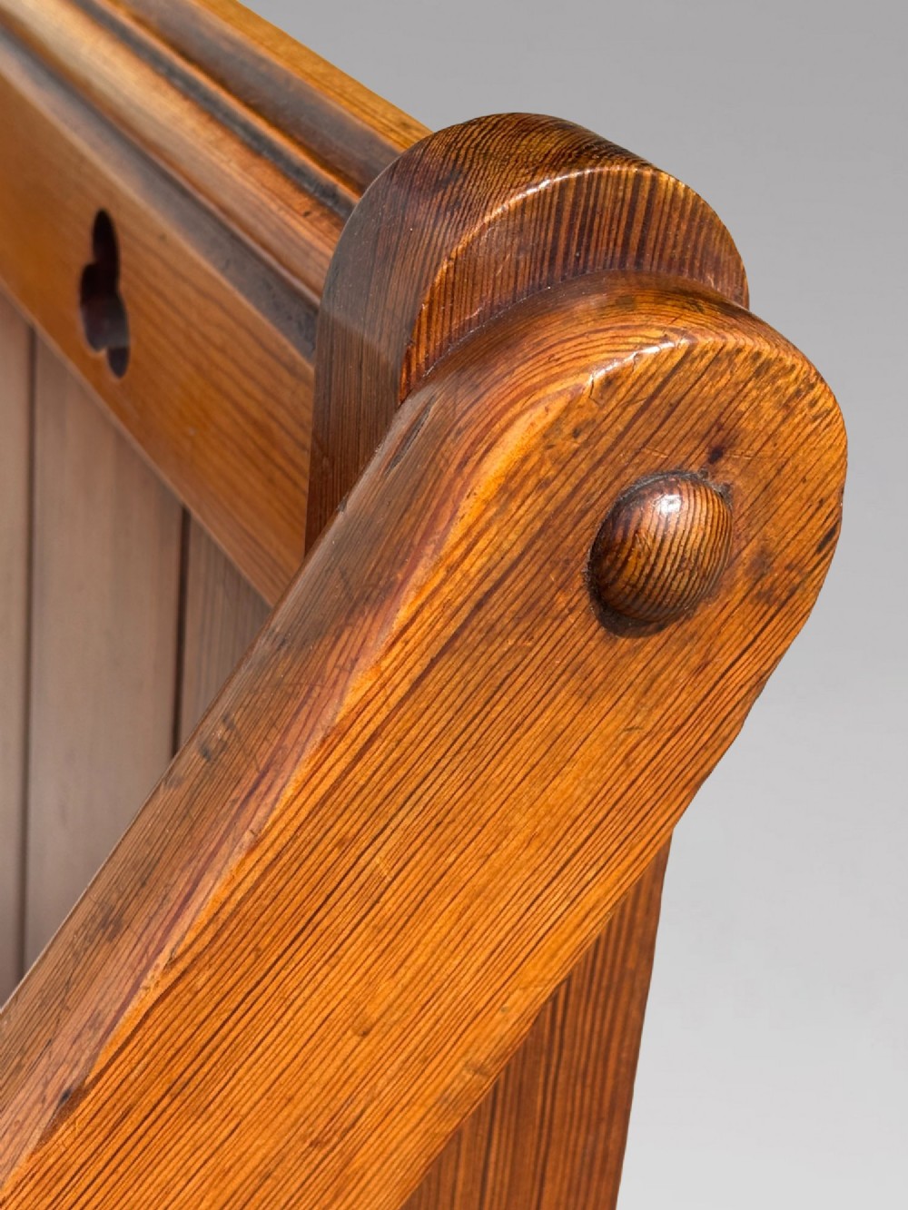 A pair of Victorian pitch pine Glastonbury armchairs featuring sloped armrests, X-frame bases, and pierced trefoil motifs on the back panels. View VIII