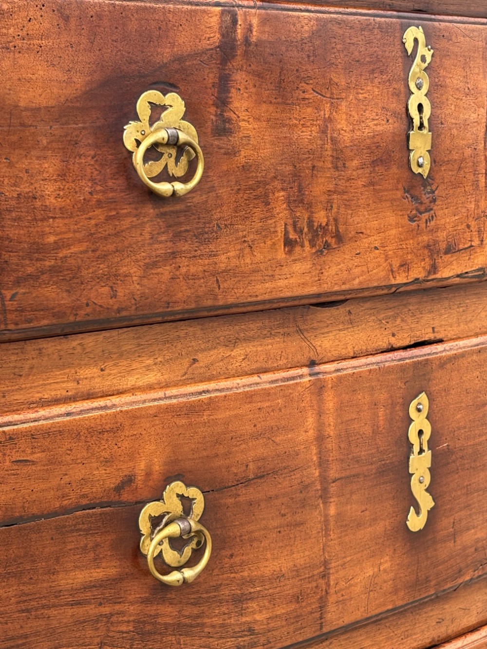 A 17th-century French Provincial walnut commode featuring three long drawers decorated with brass drop handles and central escutcheons. View III