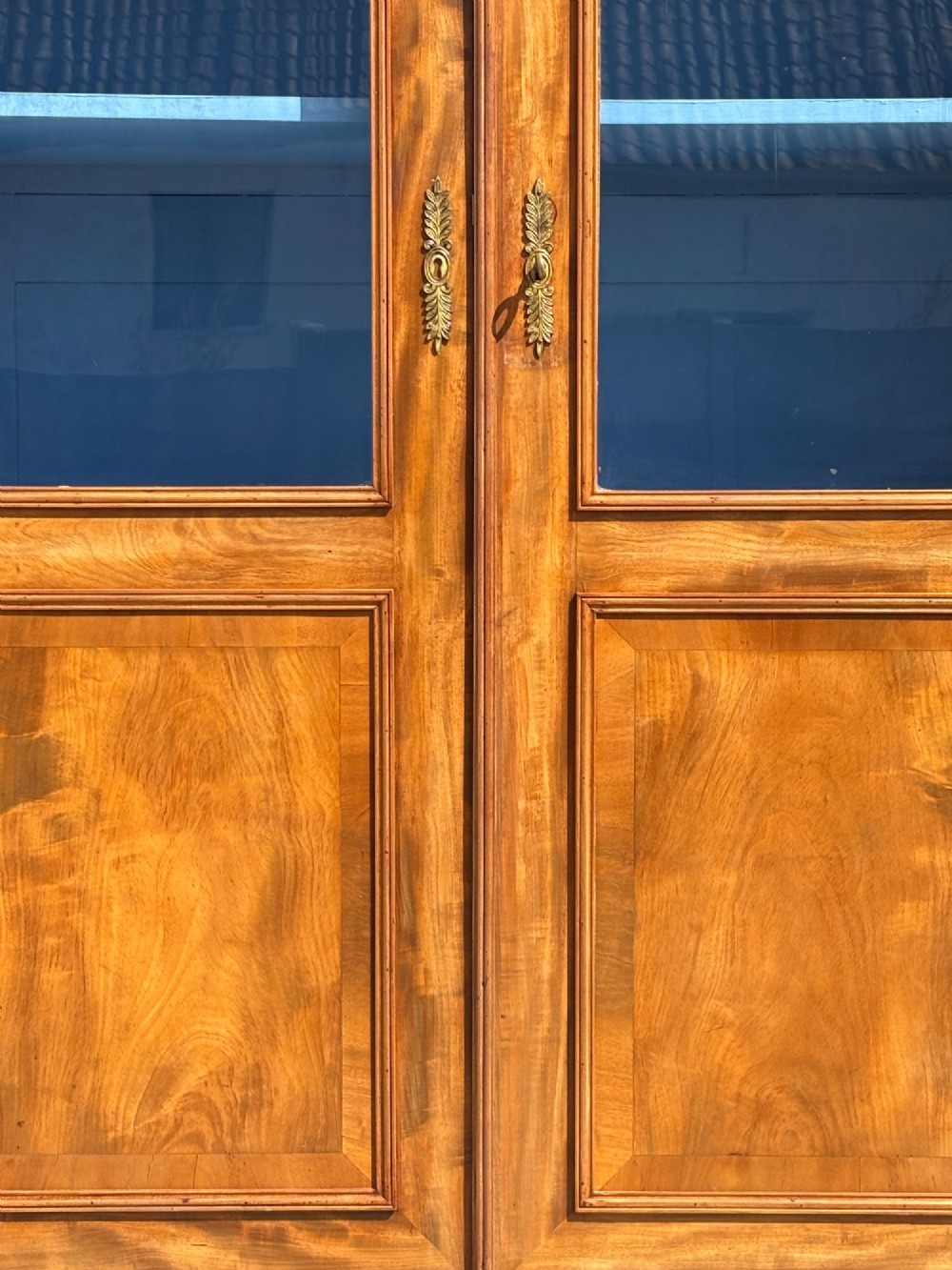 A 19th-century French Louis Philippe walnut four-door bookcase featuring glazed upper doors, panelled lower sections, and a blue painted interior. View V