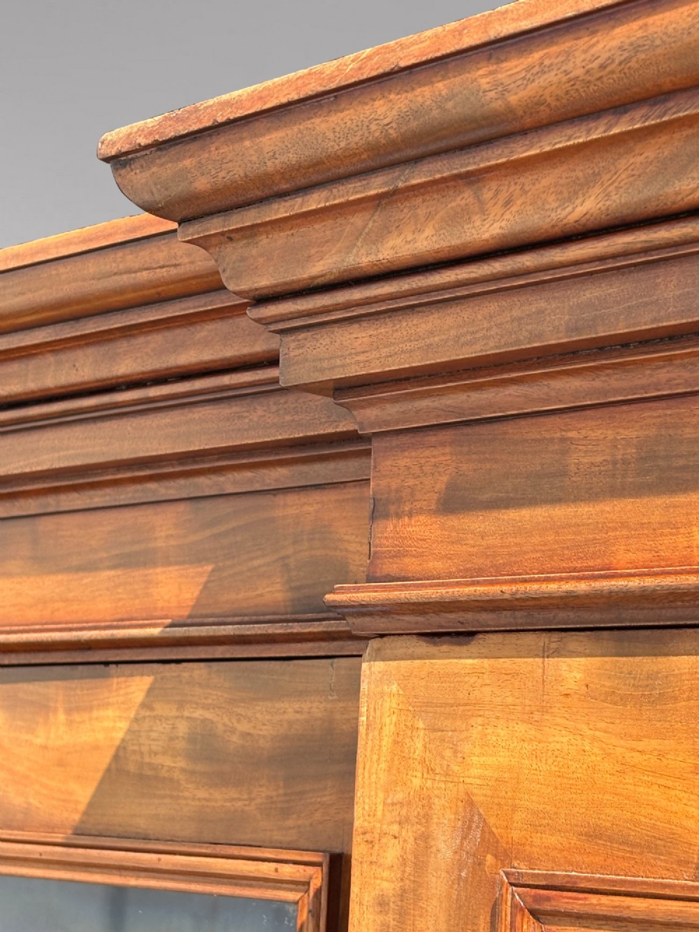 A 19th-century French Louis Philippe walnut four-door bookcase featuring glazed upper doors, panelled lower sections, and a blue painted interior. View IX