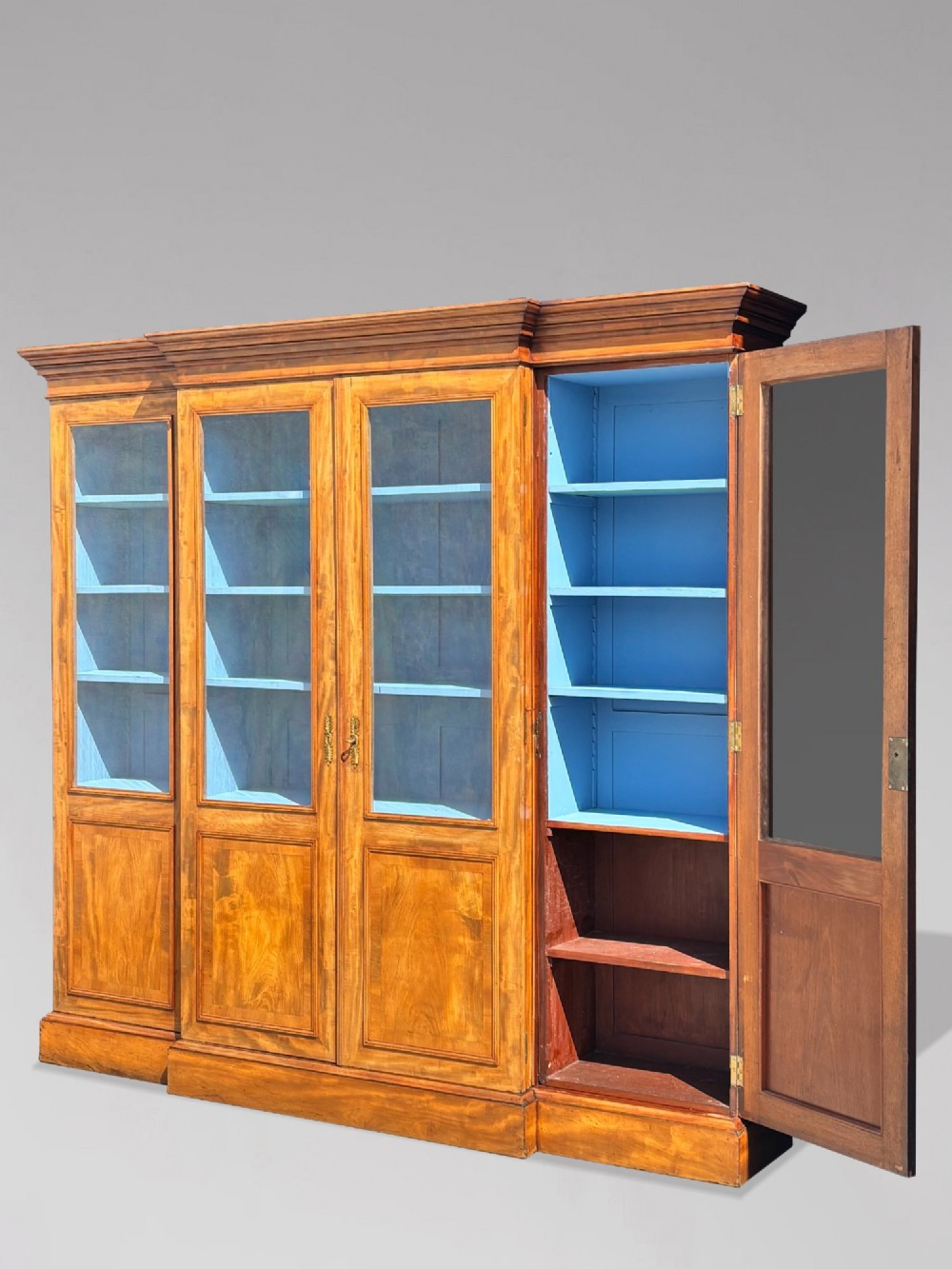A 19th-century French Louis Philippe walnut four-door bookcase featuring glazed upper doors, panelled lower sections, and a blue painted interior. View XI
