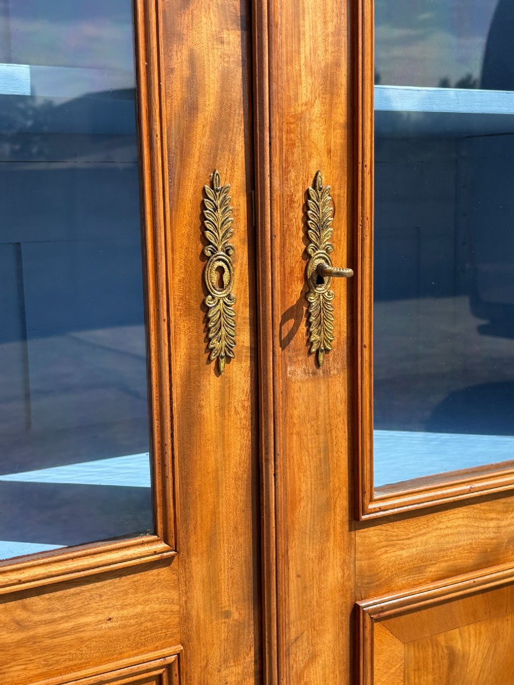 A 19th-century French Louis Philippe walnut four-door bookcase featuring glazed upper doors, panelled lower sections, and a blue painted interior. View XII