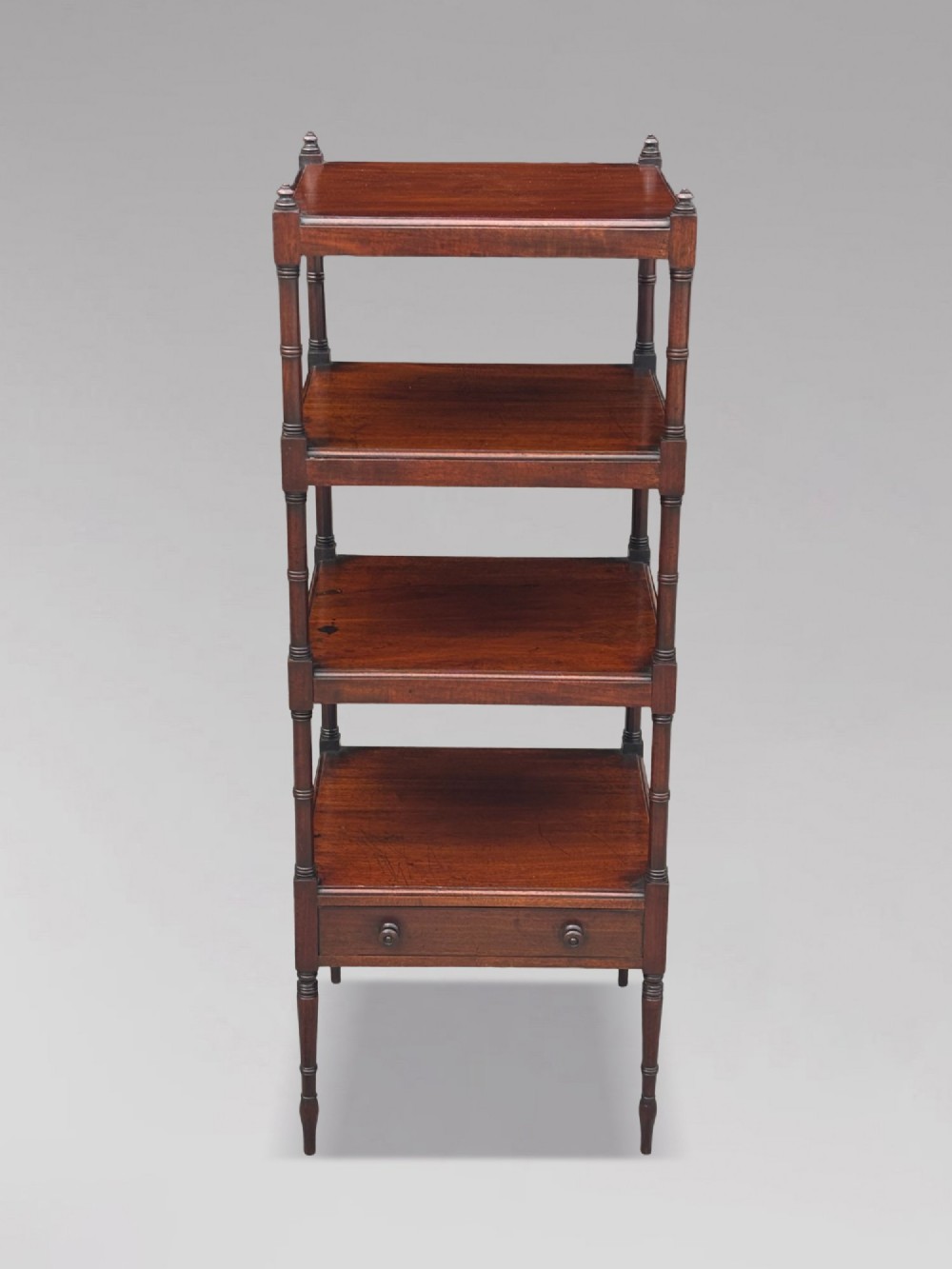 A four-tier George III mahogany whatnot features turned corner columns topped with small finials and includes a single drawer built into the lowest shelf. View II