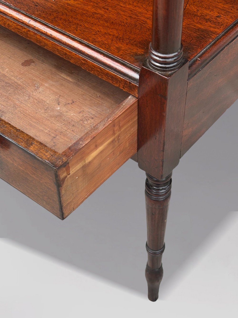 A four-tier George III mahogany whatnot features turned corner columns topped with small finials and includes a single drawer built into the lowest shelf. View V