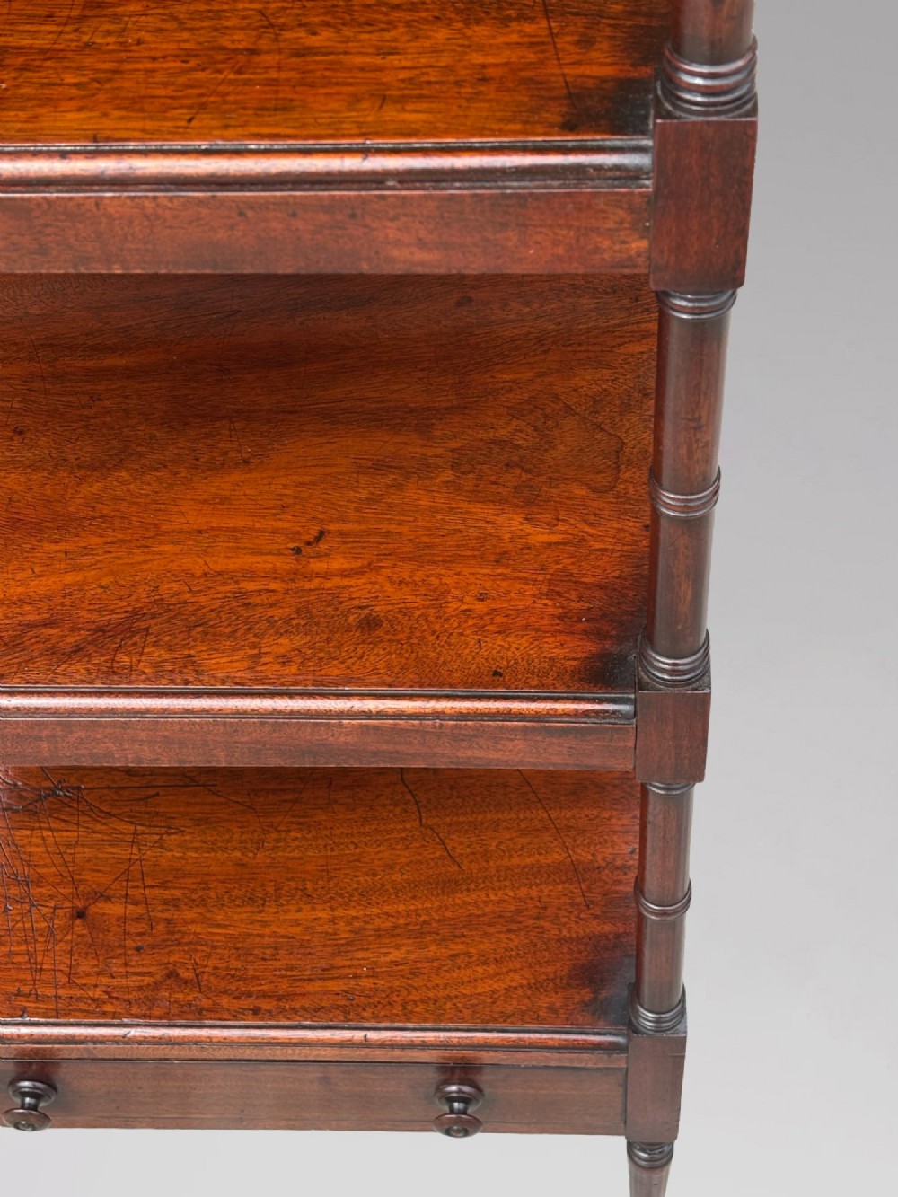 A four-tier George III mahogany whatnot features turned corner columns topped with small finials and includes a single drawer built into the lowest shelf. View VI