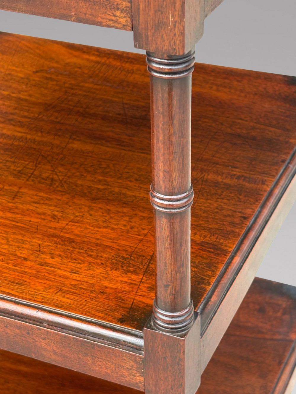 A four-tier George III mahogany whatnot features turned corner columns topped with small finials and includes a single drawer built into the lowest shelf. View VII