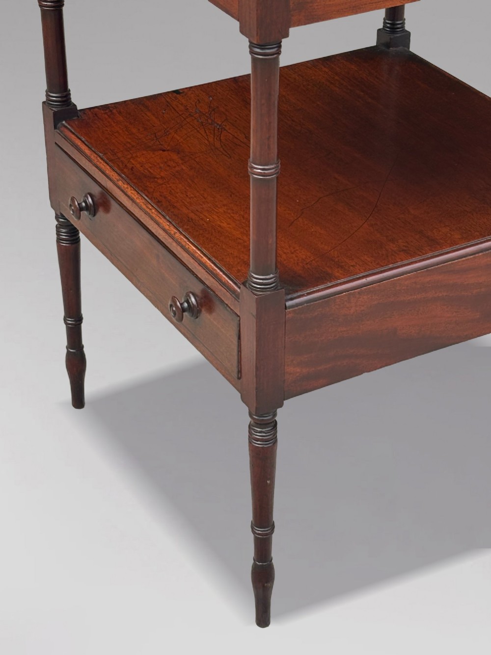 A four-tier George III mahogany whatnot features turned corner columns topped with small finials and includes a single drawer built into the lowest shelf. View VIII