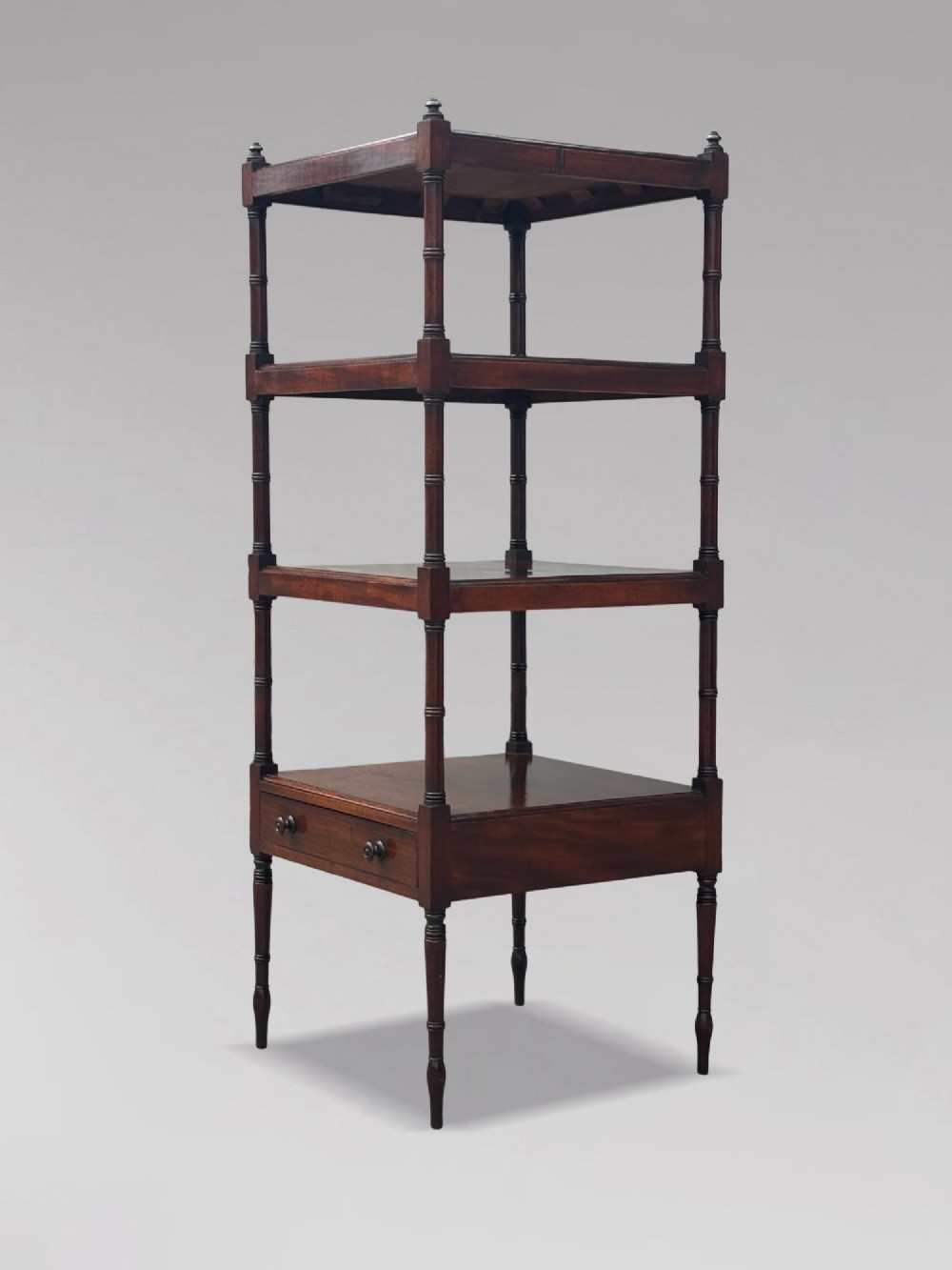 A four-tier George III mahogany whatnot features turned corner columns topped with small finials and includes a single drawer built into the lowest shelf. View IX