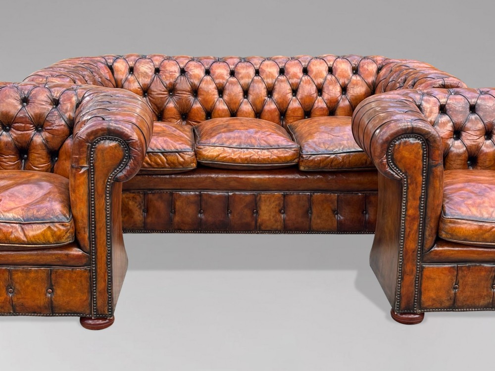 A pair of late Victorian deep-buttoned brown leather Chesterfield club armchairs with rolled arms, brass studding, and turned wooden feet. View VIII