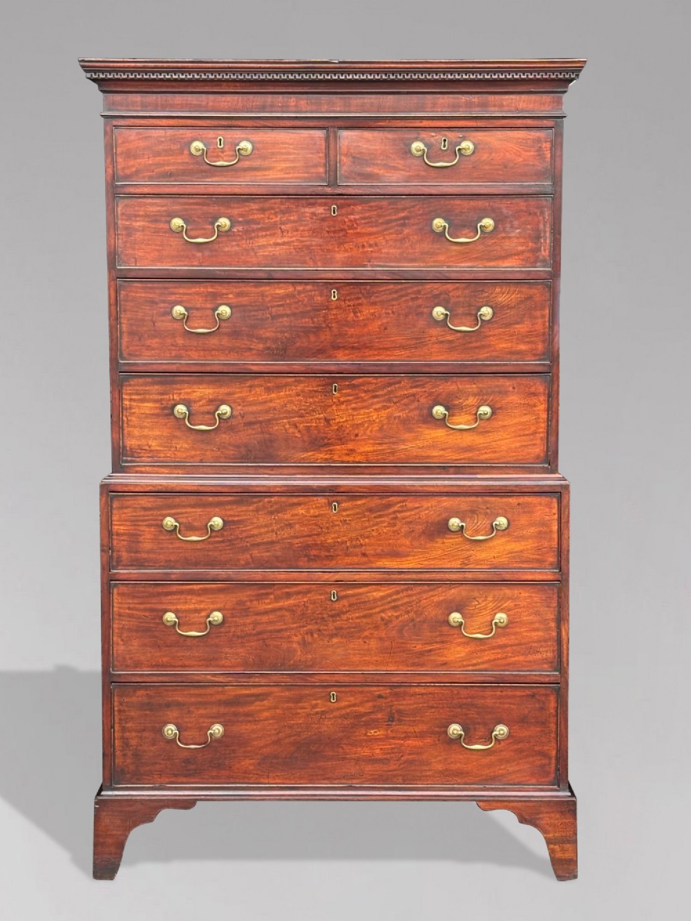 An 18th-century George III mahogany chest on chest featuring upper and lower drawer sections with brass handles and bracket feet. View II
