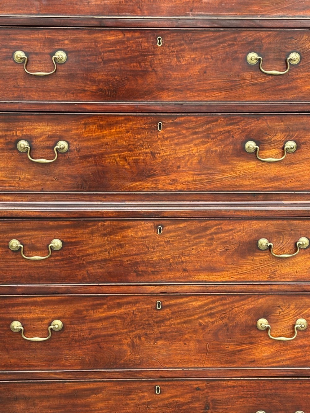 An 18th-century George III mahogany chest on chest featuring upper and lower drawer sections with brass handles and bracket feet. View IV