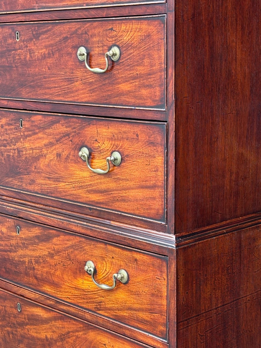 An 18th-century George III mahogany chest on chest featuring upper and lower drawer sections with brass handles and bracket feet. View V