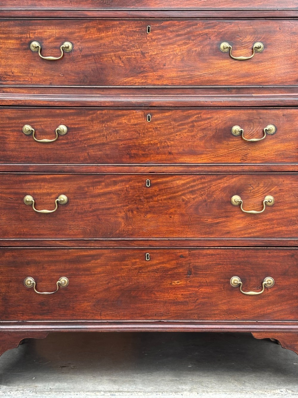 An 18th-century George III mahogany chest on chest featuring upper and lower drawer sections with brass handles and bracket feet. View VII