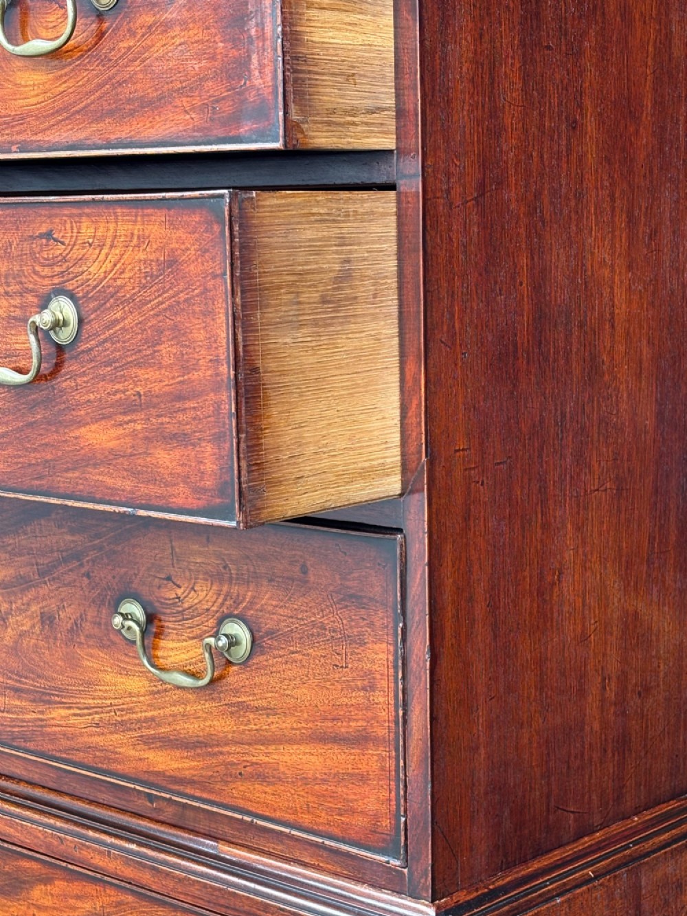 An 18th-century George III mahogany chest on chest featuring upper and lower drawer sections with brass handles and bracket feet. View VIII