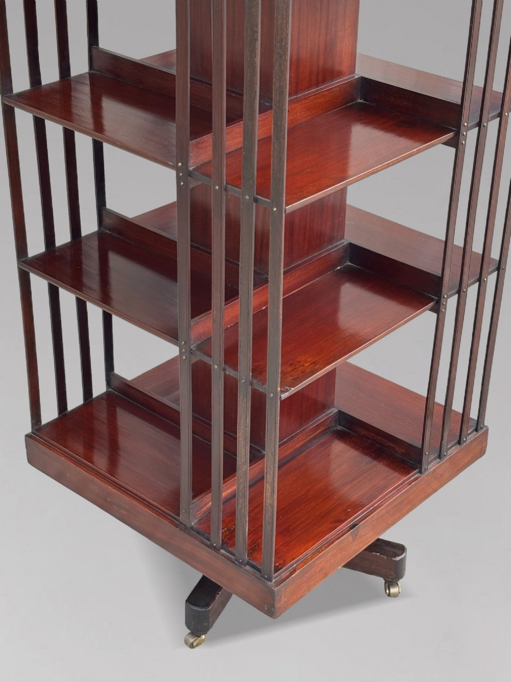 A four-tier Victorian mahogany revolving bookcase featuring vertical slatted sides, a square top, and a rotating base on brass castors. View IV