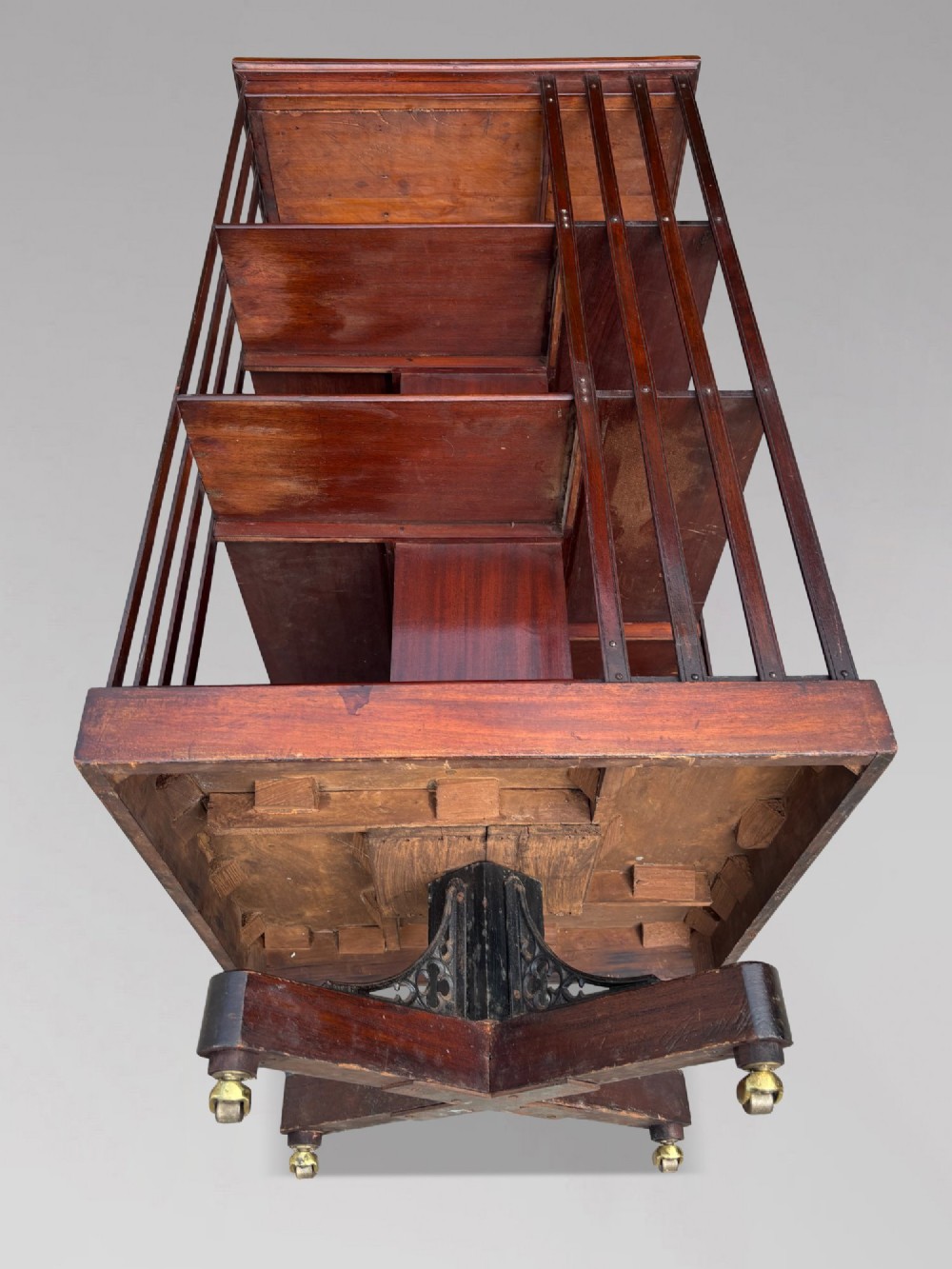 A four-tier Victorian mahogany revolving bookcase featuring vertical slatted sides, a square top, and a rotating base on brass castors. View V