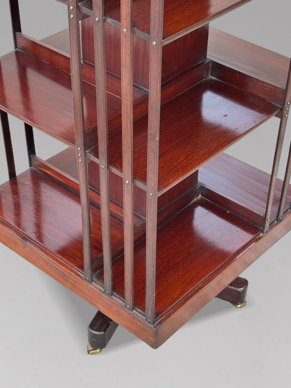 A four-tier Victorian mahogany revolving bookcase featuring vertical slatted sides, a square top, and a rotating base on brass castors. View VIII