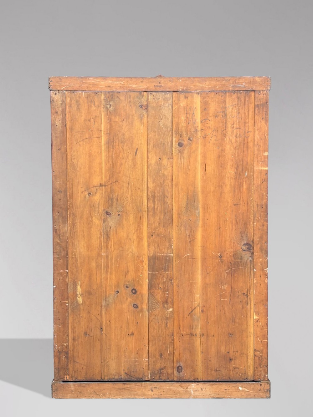 A late 19th-century pitch pine Arts and Crafts wardrobe featuring vertical slatted upper door panels, chevron lower panels, and a carved cresting rail. View VII