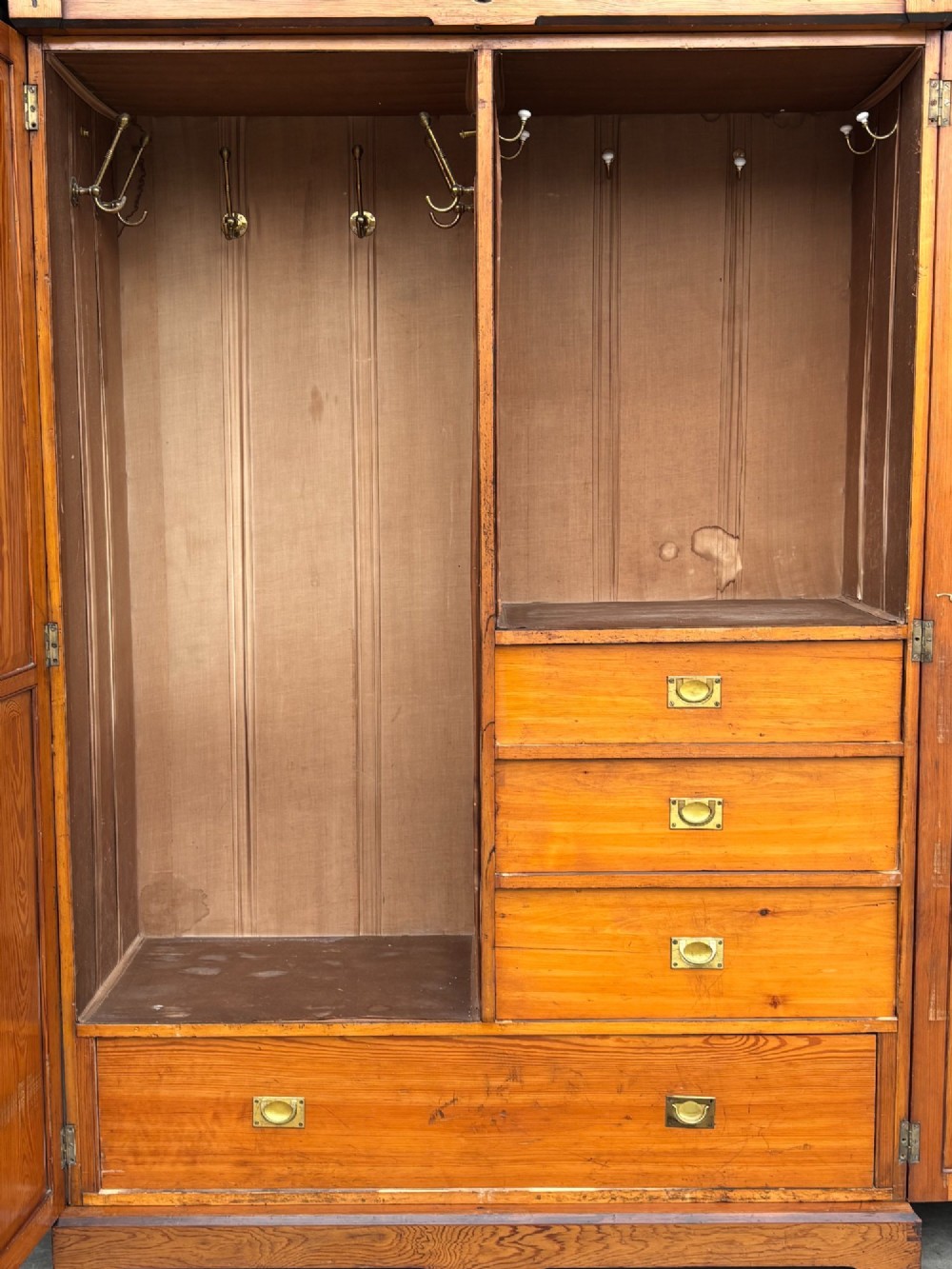 A late 19th-century pitch pine Arts and Crafts wardrobe featuring vertical slatted upper door panels, chevron lower panels, and a carved cresting rail. View XI