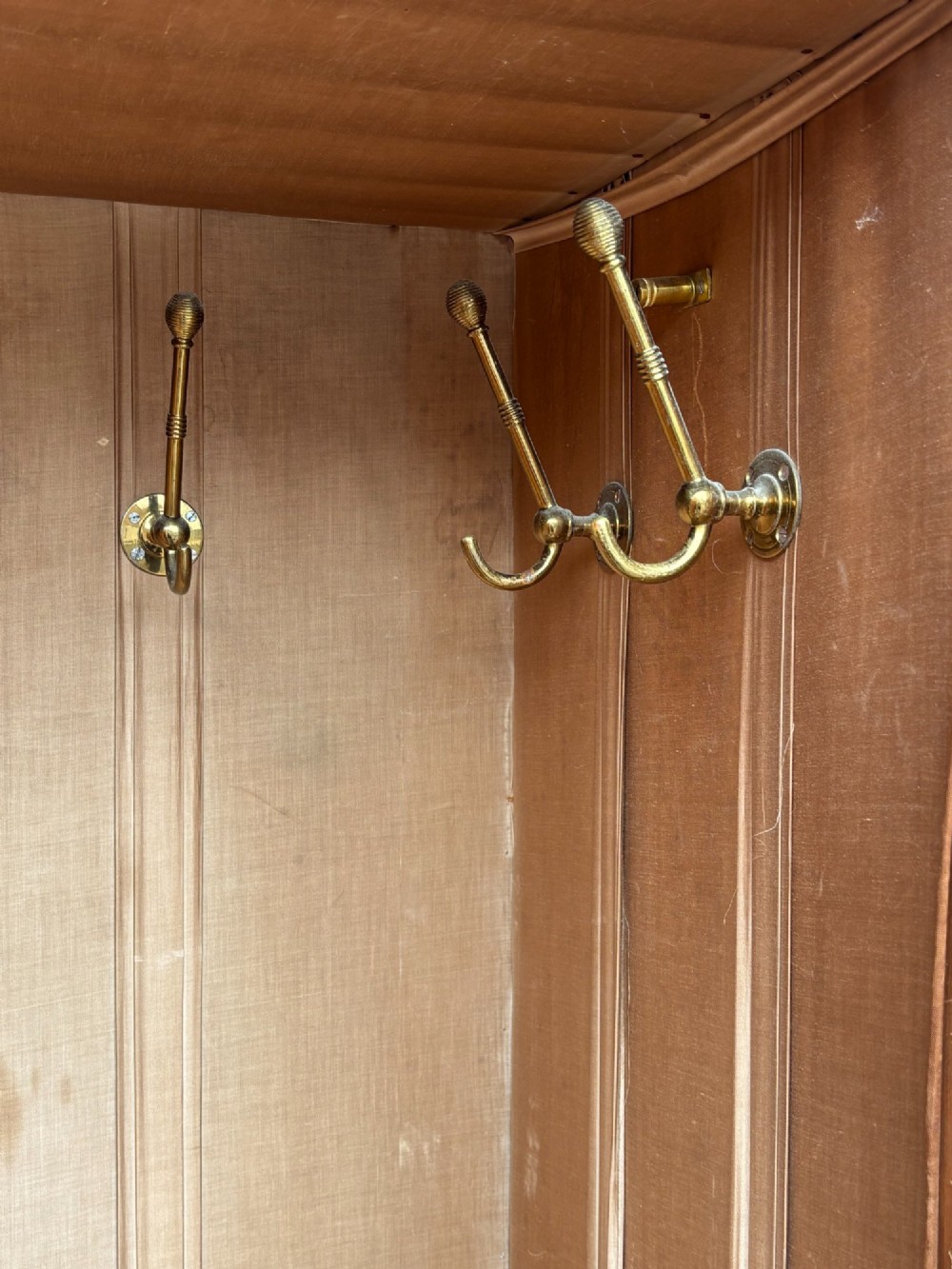 A late 19th-century pitch pine Arts and Crafts wardrobe featuring vertical slatted upper door panels, chevron lower panels, and a carved cresting rail. View XII