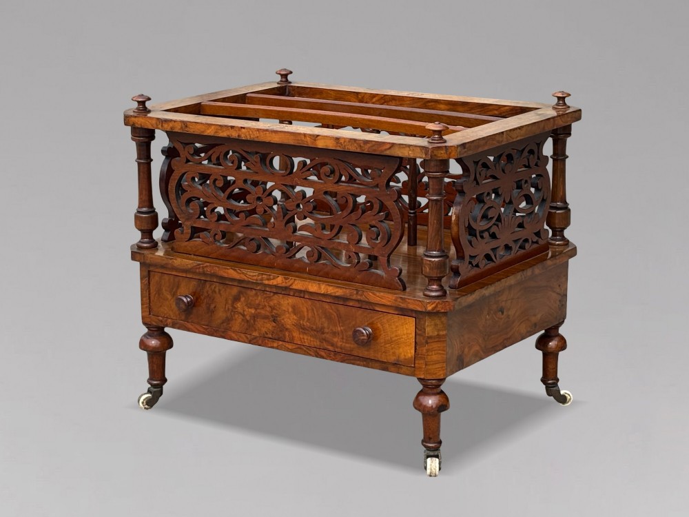 A mid-19th-century Victorian walnut music canterbury featuring open fretwork dividers, turned corner columns, a single base drawer, and turned legs with ceramic castors. View III