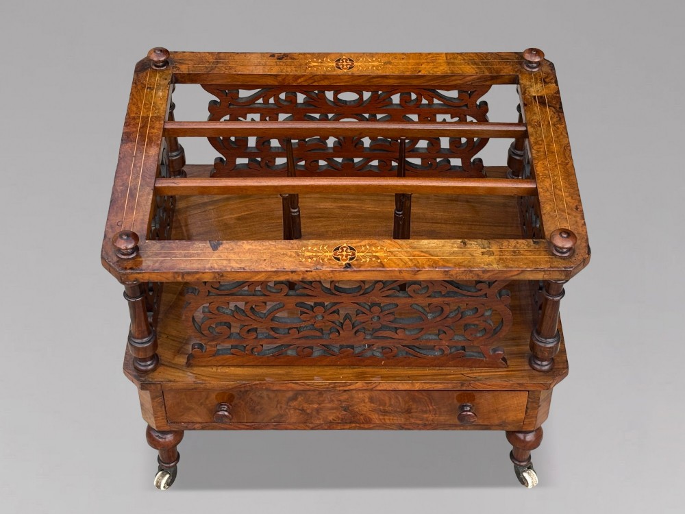 A mid-19th-century Victorian walnut music canterbury featuring open fretwork dividers, turned corner columns, a single base drawer, and turned legs with ceramic castors. View VIII