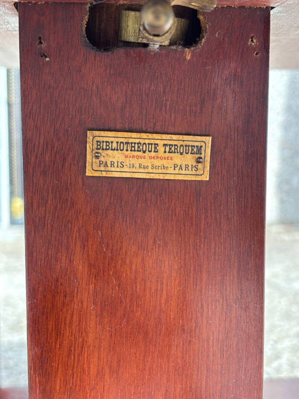 A tall nineteenth-century mahogany revolving bookcase featuring open slatted sides, tiered shelving, pull-out circular trays, and an angled reading slope with a burgundy leather surface. View IV