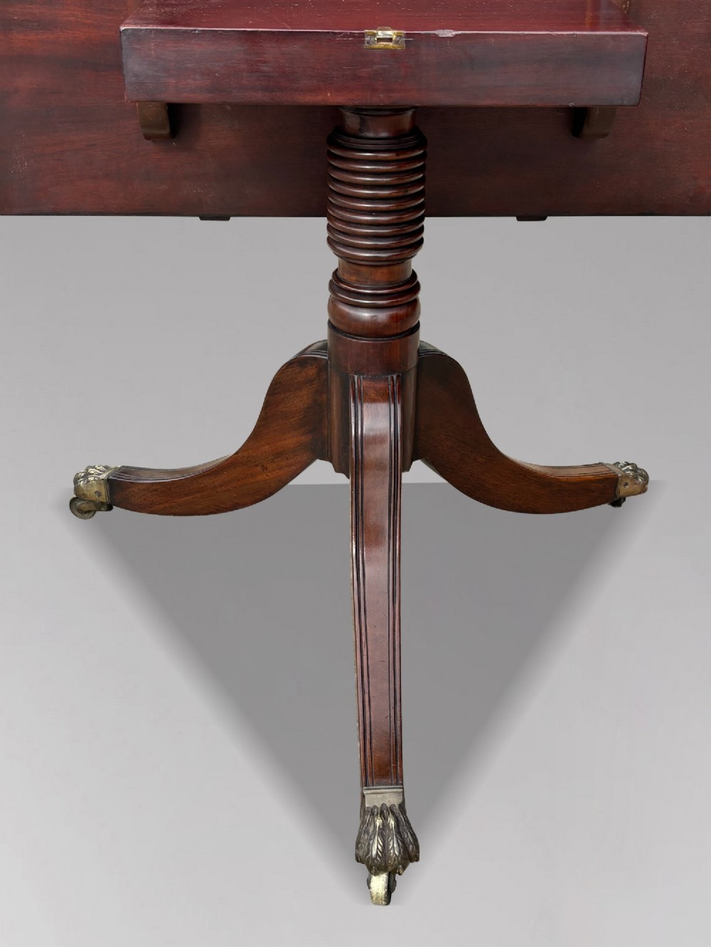 An early 19th-century Georgian mahogany twin pedestal dining table with a removable extension leaf, turned support pillars, and splayed legs ending in brass toe castors. View VIII
