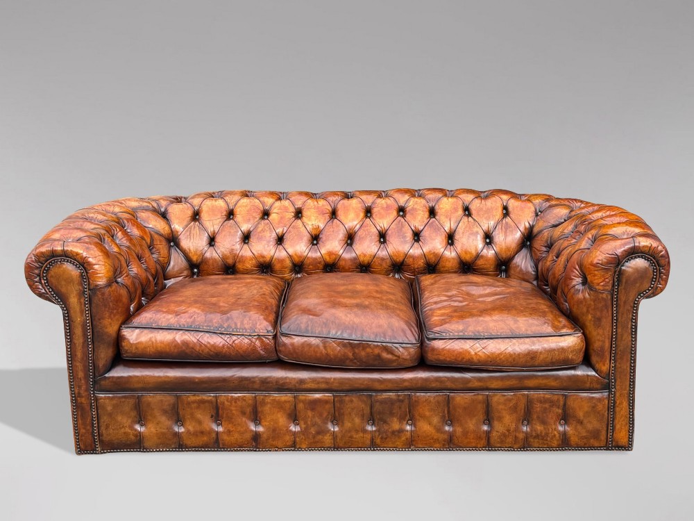 A nineteenth-century Victorian three-seater Chesterfield sofa upholstered in aged warm brown leather with deep button tufting and nailhead trim. View III
