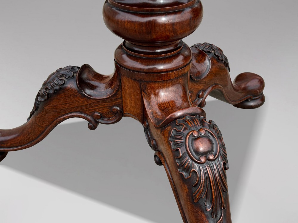 A circular William IV period rosewood centre table with a figured top on a carved pedestal and tripod base. View V