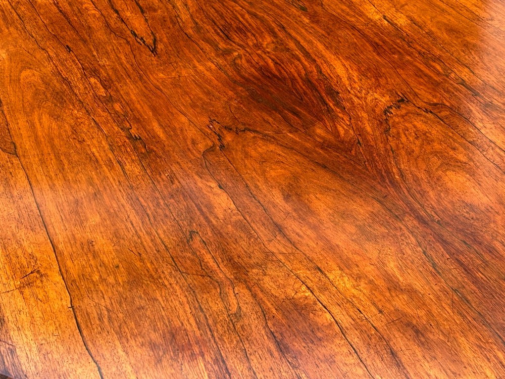 A circular William IV period rosewood centre table with a figured top on a carved pedestal and tripod base. View IX